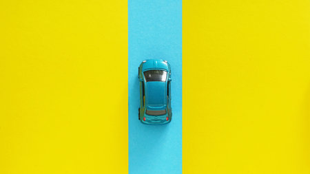 The Journey to a Dream on The Road of Opportunity as Moving into the future are shown by Blue car driving on abstract yellow and blue backgroundの写真素材