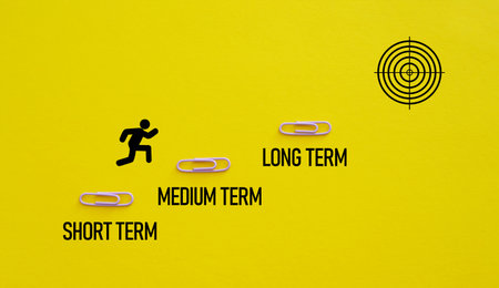 Short term medium term and long term are shown using a text and man running toward the goalの写真素材