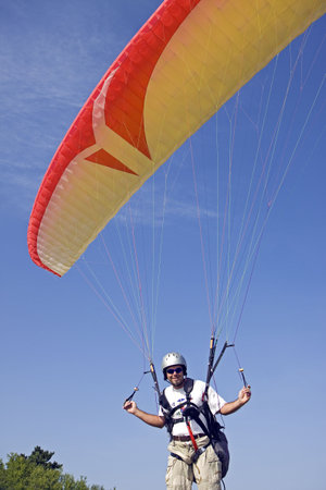 Paraglider pilot prepares to depart flightの写真素材