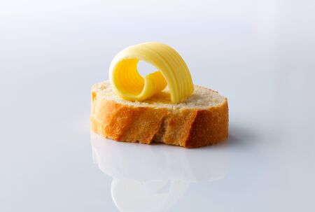 Butter curl or roll on a slice of baguette breadの写真素材