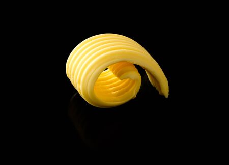 Butter curl roll isolated against black backgroundの写真素材