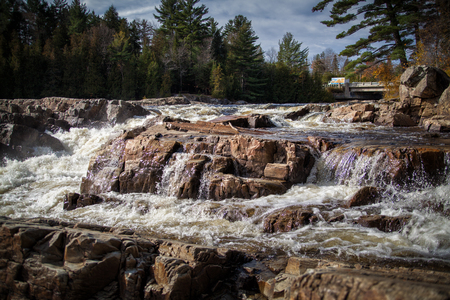 Stormy and frothy stream cascades of cold waterの写真素材