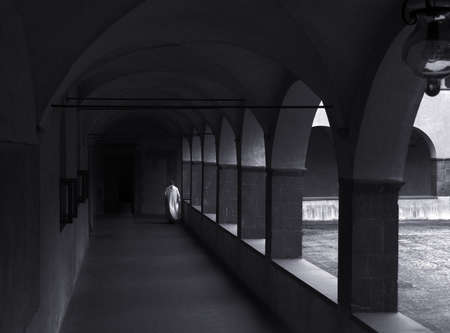 a monk walking alone in the monastery cloistersの写真素材