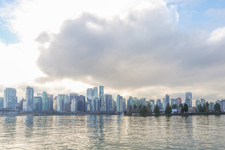 Vancouver Jan 1 2025. CanadaSkyl marina with yachts and sailboats reflecting on still water, Vancouver city skyline in background, cloudy sky, peaceful urban waterfront scene.のeditorial素材