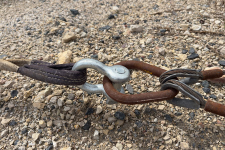 Tow strap shackle chain on gravel.