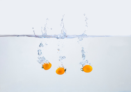 Tomatoes falling into the waterの写真素材