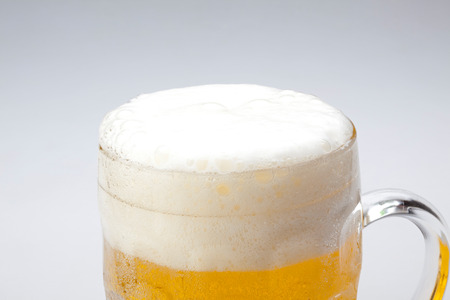 mug fresh beer with cap of foamの写真素材
