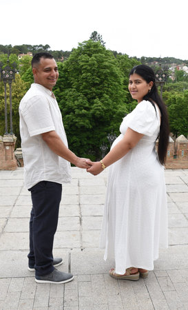 Man and woman holding hands and smiling at the camera in the parkの写真素材