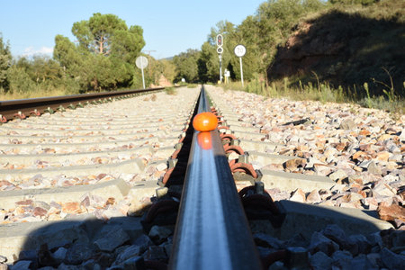 Photo of a tangerine on the railway tracks, in the mountainsの写真素材