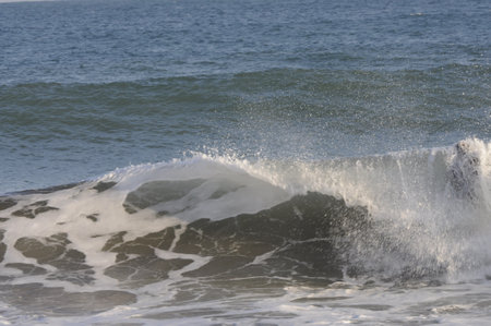 Big sea wave breaking on the shore and splashing on the beachの写真素材