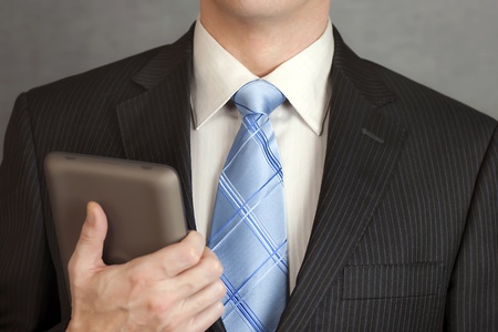 A close-up shot of a businessman holding a tablet computer.の写真素材