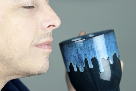 Close-up of a serene man smelling his mug.の写真素材