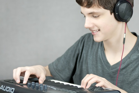 Close-up of a headphone wearing teen adjusting his keyboard.の写真素材