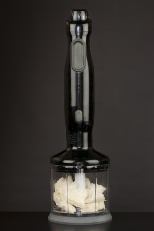 Close-up of a hand blender containing bread to be crumbed.の写真素材