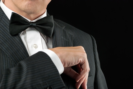 Close-up of a man in a tux tucking in his pocket square の写真素材