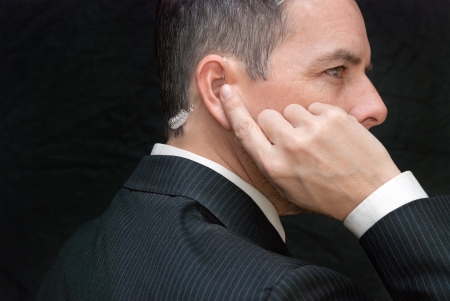 Close-up of a secret service agent listening to his earpiece, side.の写真素材