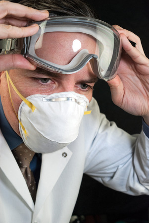Close-up of a Doctor wearing a mask and putting on goggles の写真素材