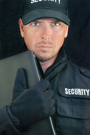 Close-up of security holding a laptop to camera の写真素材