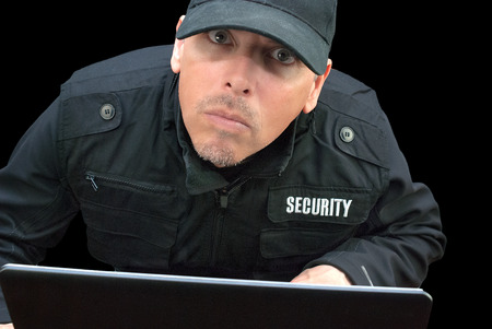 Close-up of security working on a laptop, looking to camera の写真素材