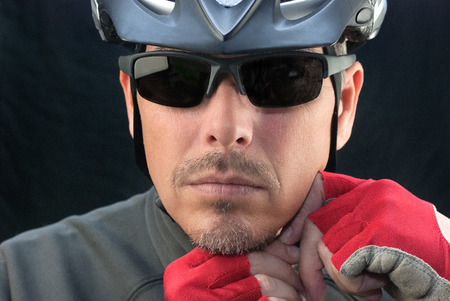 Close-up of bicycle courier putting on helmet の写真素材