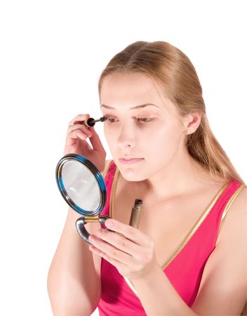 young woman putting make up on her face. Isolatedの写真素材