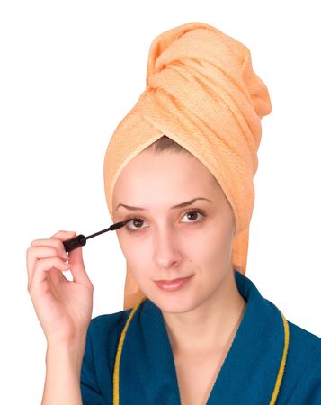 young woman putting make up on her face. Isolatedの写真素材