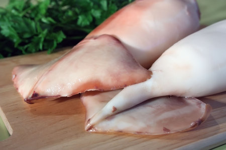 boiled calamar close-up on chopping board in kitchenの写真素材