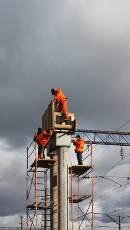 builder in orange working on concrete piles の写真素材