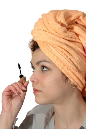 young woman putting make up on her face. Isolatedの写真素材