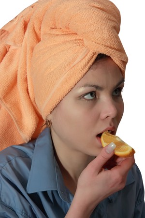 Girl eating a orange. Isolated on whiteの写真素材