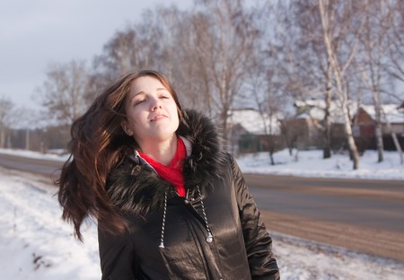 Portrait of brunette long-haired girl  on winter streetの写真素材
