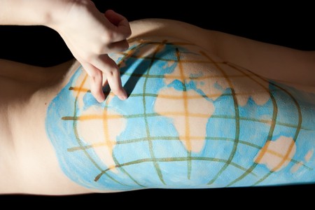 tourist on Painting globe on female fanny. Isolated on blackの写真素材