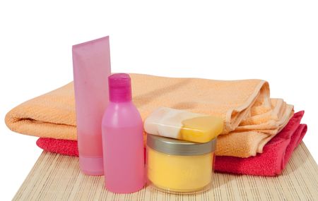 Colored toilletries with pink towel. Isolated over whiteの写真素材