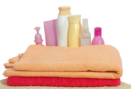 Colored toilletries with pink towel. Isolated over whiteの写真素材