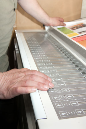 Worker's hands on the electronic control panel of offset machineの写真素材