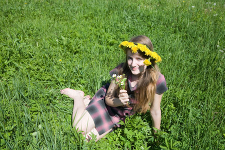 long-haired teen girl  in a chaplet against a meadowの写真素材