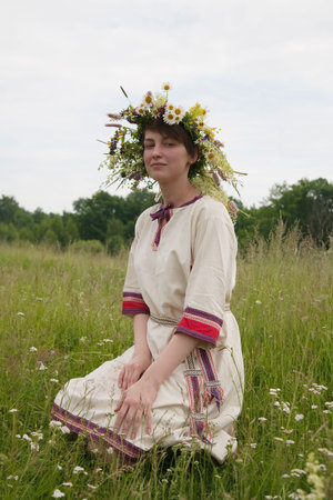 girl in flowers wreath and traditional clothes