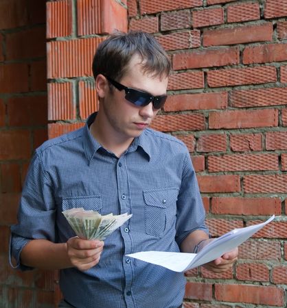 foreman with documents and money  against  the brick wallの写真素材