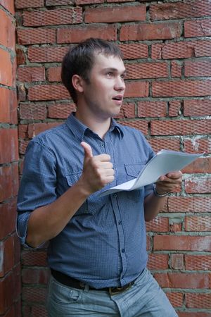 Happy builder with documents against  the brick wallの写真素材
