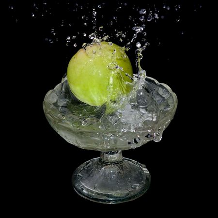 Apple falls into water over black backgroundの写真素材