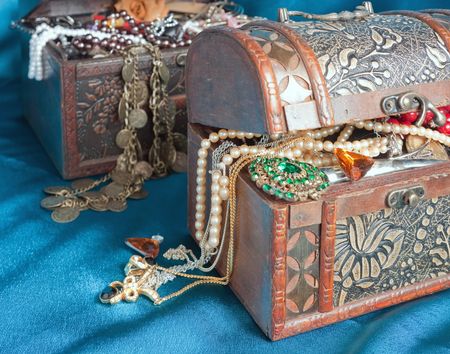 Two wooden treasure chests with valuables on blue textileの写真素材