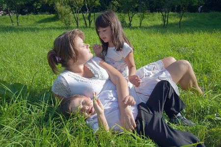 Happy mother with her children  sit in grass の写真素材