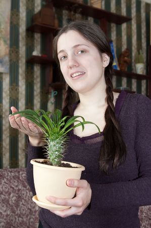 Attractive woman with cactus flower in the pot at her homeの写真素材