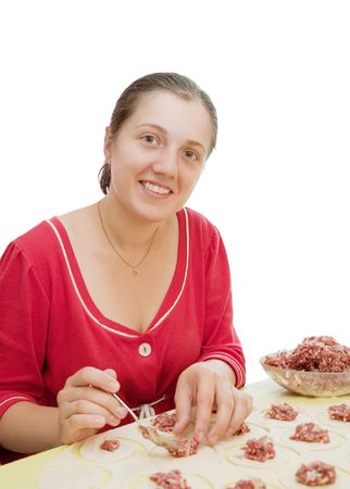 Woman making meat dumplings from stuffing and doughの写真素材
