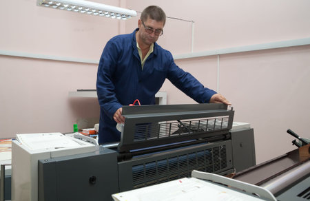 Printer working at his modern offset machine