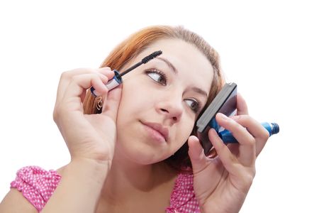 young girl mascaras her eye-lashes over whiteの写真素材