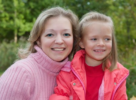 mother with little girl against autumn park の写真素材