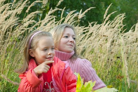 mother with her daughter against autumn natureの写真素材