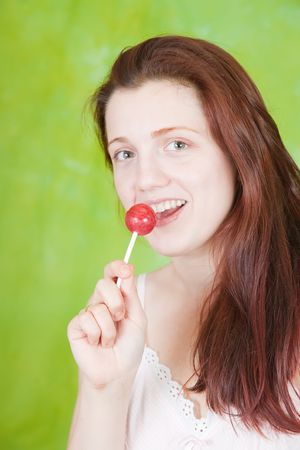  Portrait of sexy girl licking lollipop over greenの写真素材