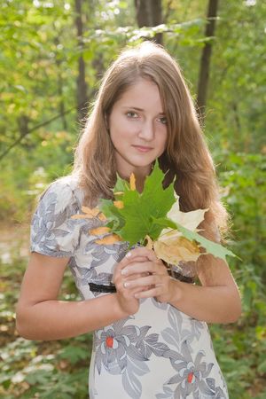 long-haired  teen girl posing in autumn parkの写真素材